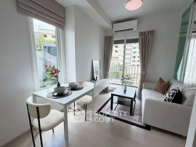 Chic modern living room with balcony access, stylish decor, and abundant natural light in urban apartment.