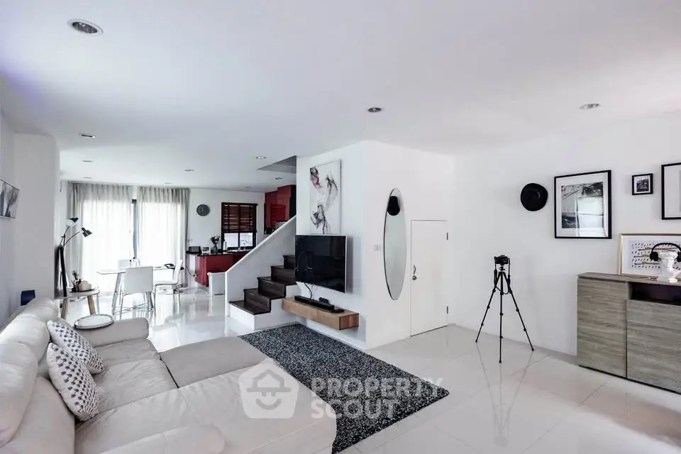 Spacious modern living room with sleek design and open layout, featuring a cozy seating area and stylish decor.