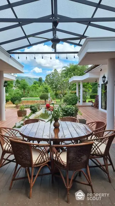 Charming outdoor patio with elegant wooden furniture and lush garden view