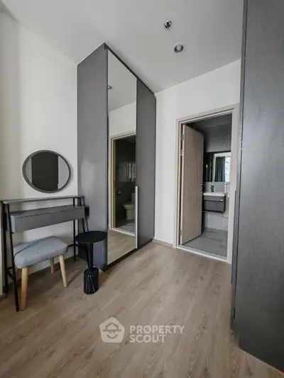 Modern bedroom with stylish furniture and ensuite bathroom in a contemporary apartment.
