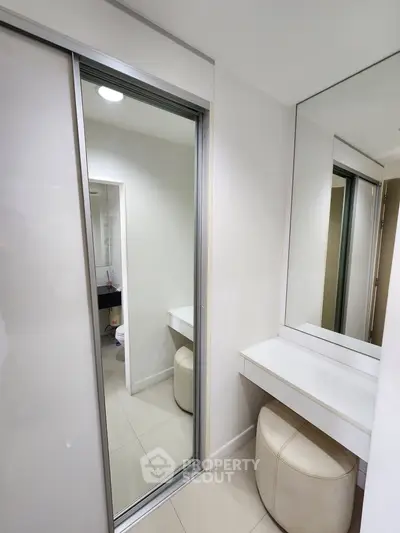 Modern bathroom with sleek vanity and large mirror in contemporary apartment.
