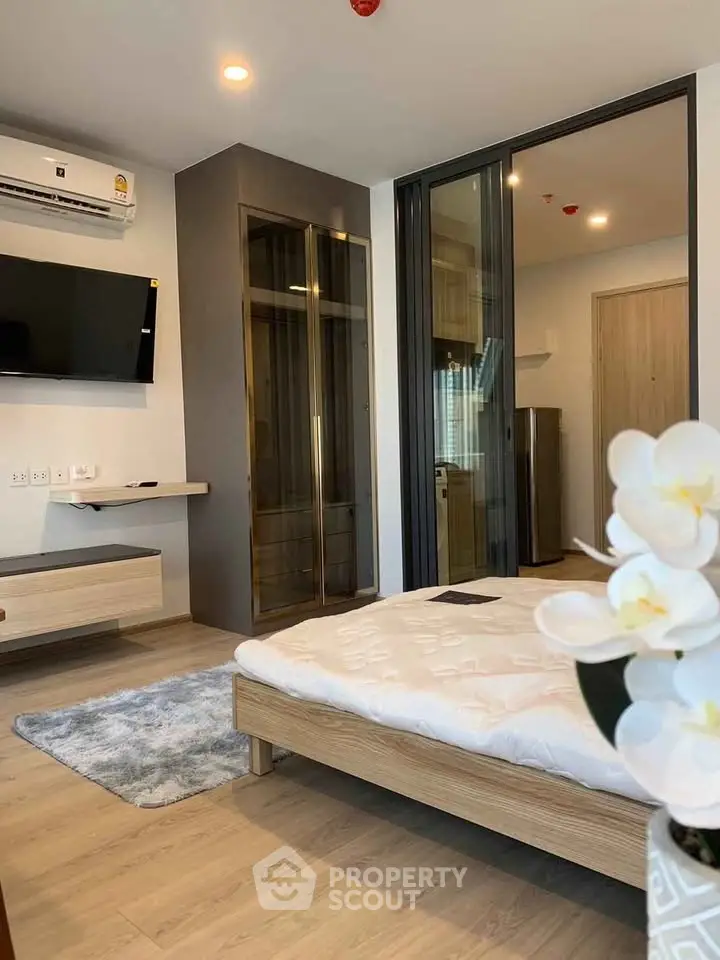 Modern bedroom with sleek design, featuring a wall-mounted TV and stylish wardrobe.