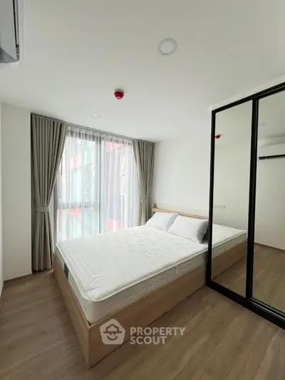 Modern bedroom with large mirror closet and natural light