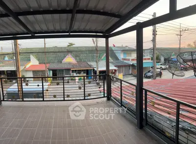 Spacious balcony with urban view and metal railing, perfect for relaxation.