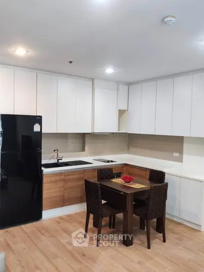 Modern kitchen with sleek cabinetry and dining area in a stylish apartment