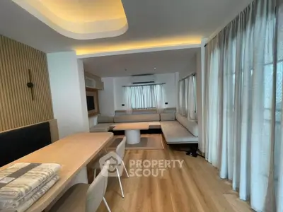 Modern living room with stylish furniture and ambient lighting, featuring a cozy seating area and elegant wooden flooring.