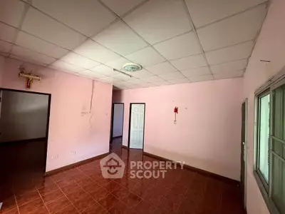 Spacious room with tiled floor and pink walls, ideal for customization.