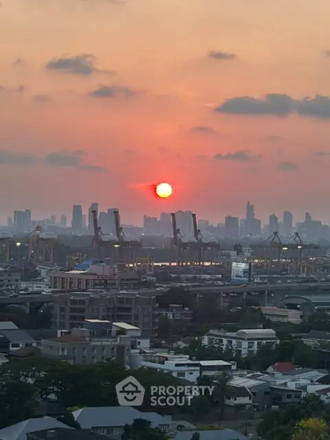 Stunning cityscape view at sunset with skyline and industrial cranes.