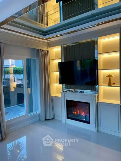 Luxurious living room with modern fireplace and large TV, featuring elegant lighting and floor-to-ceiling windows.