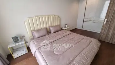Luxurious bedroom with elegant decor and plush bedding in modern apartment.