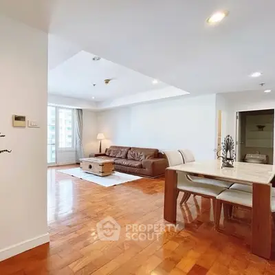 Spacious open-plan living and dining area with wooden flooring and modern furniture.