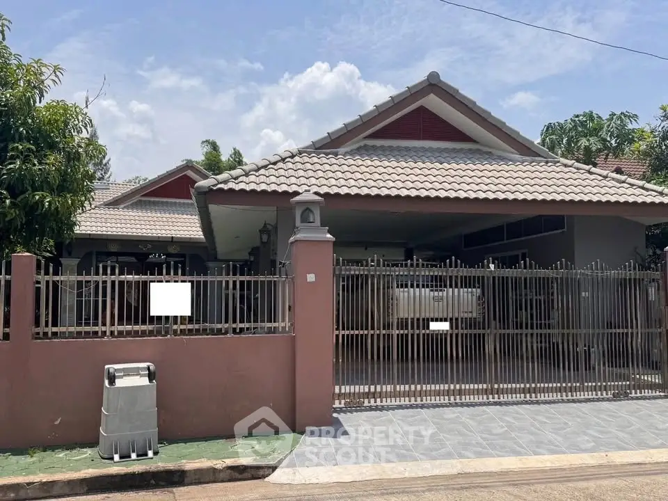 Charming suburban house with tiled roof and gated driveway, perfect for family living.