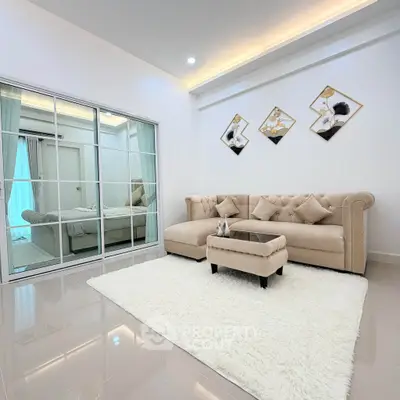 Elegant living room with plush beige sofa, chic decor, and glossy tiled floor in modern apartment.