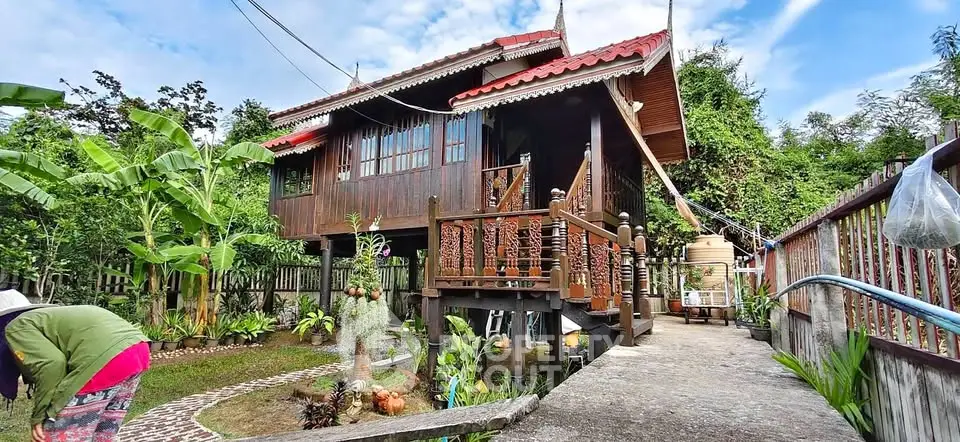 Charming traditional wooden house with lush garden and elevated entrance, perfect for serene living.