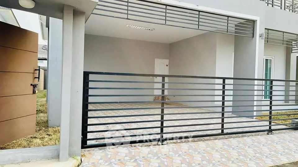 Modern townhouse exterior with gated parking area and sleek design.