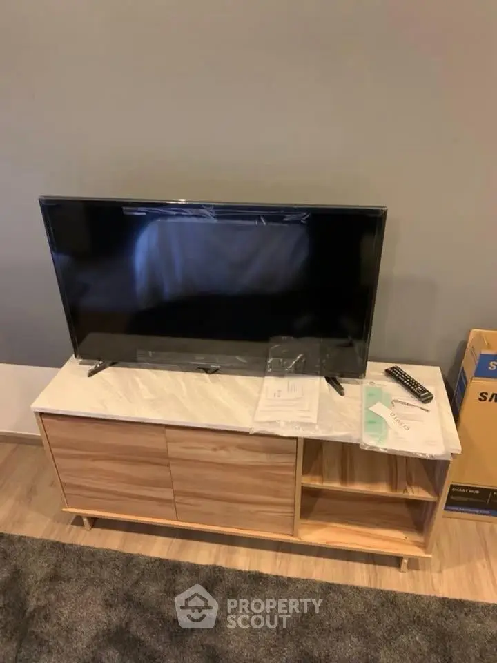 Modern living room with sleek TV stand and flat-screen TV, perfect for entertainment setup.