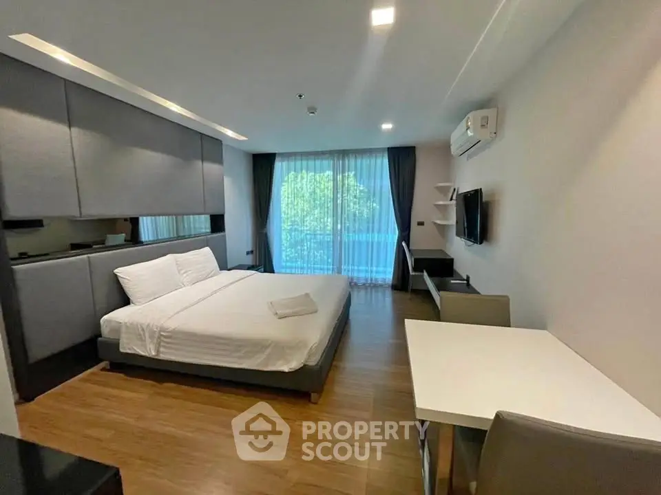 Modern bedroom with sleek design and natural light, featuring a comfortable bed and stylish furnishings.