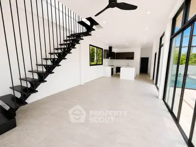 Modern open-plan living room with sleek staircase and pool view, perfect for contemporary lifestyle.