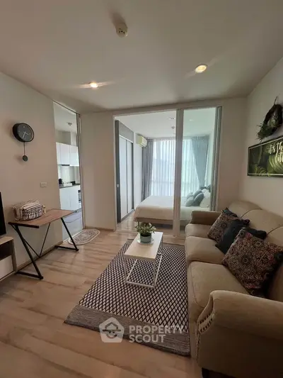 Modern living room with cozy sofa and stylish decor adjacent to a bright bedroom.