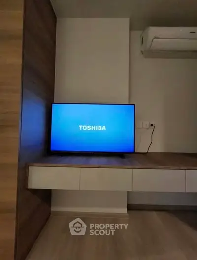 Modern living room with sleek wooden paneling and Toshiba TV, featuring minimalist design and air conditioning.