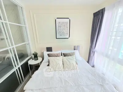 Bright and cozy bedroom with modern decor and large window for natural light.