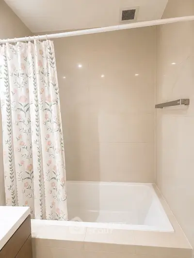 Modern bathroom with elegant bathtub and floral shower curtain