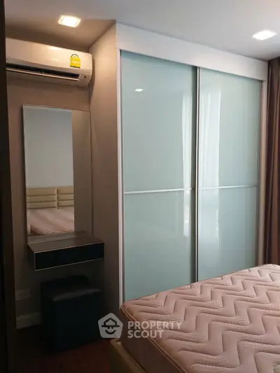 Modern bedroom with sleek wardrobe and air conditioning unit
