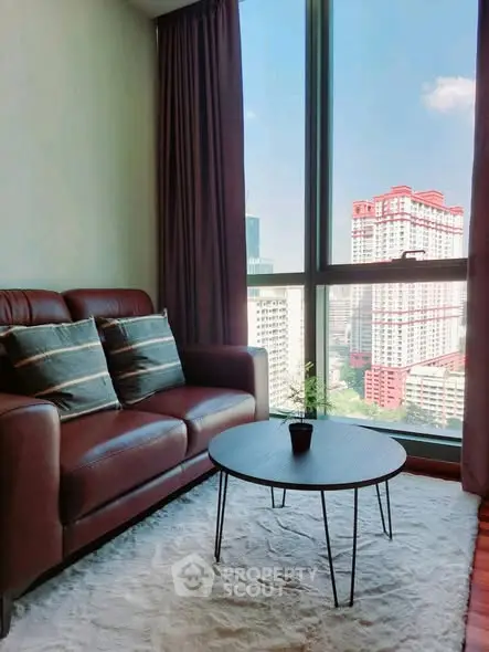 Cozy living room with city view, featuring a leather sofa and modern coffee table.