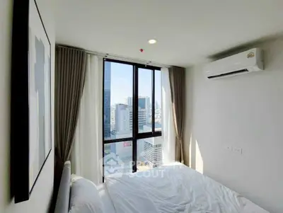 Modern bedroom with city view and air conditioning in high-rise apartment.
