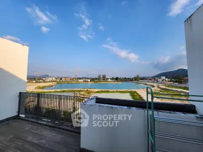 Stunning balcony view overlooking serene water and distant mountains, perfect for relaxation.