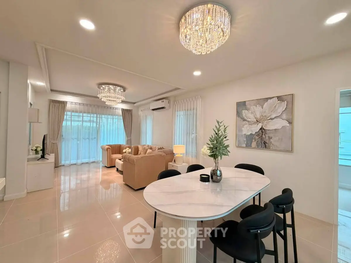 Luxurious open-plan living room with elegant chandeliers and modern decor