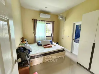 Cozy bedroom with natural light, featuring a comfortable bed and modern furnishings, ideal for relaxation.