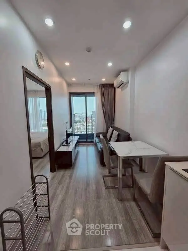 Modern apartment interior with cozy living area and city view balcony.