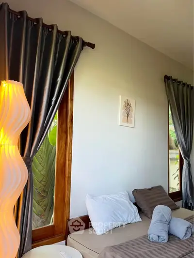 Cozy bedroom with elegant curtains and soft lighting, perfect for relaxation.