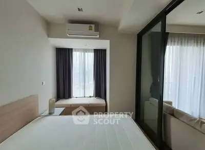 Modern bedroom with large window and air conditioning, featuring a cozy seating nook.
