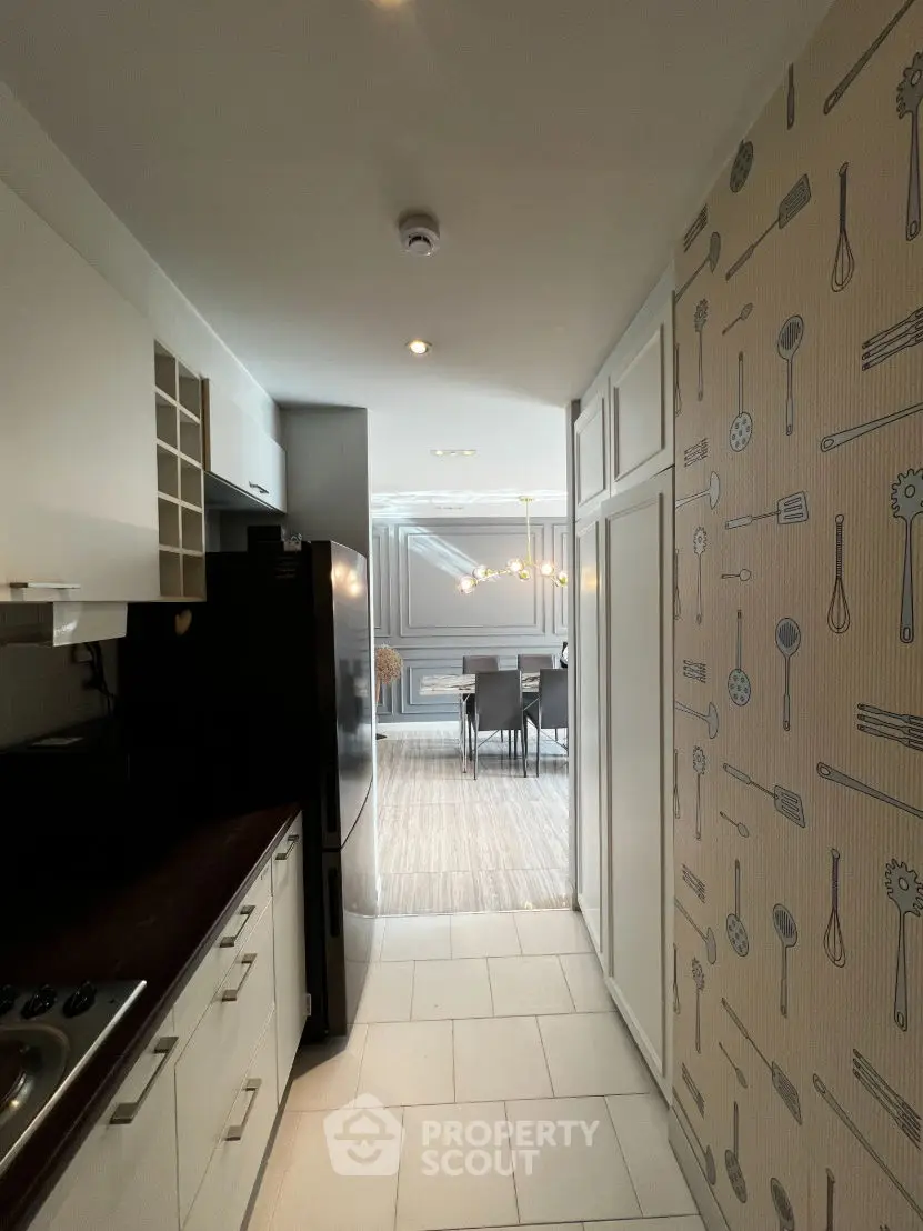 Stylish kitchen with modern appliances leading to elegant dining area