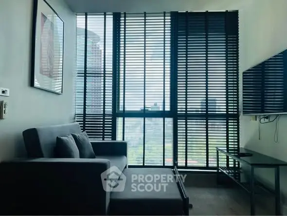 Modern living room with large windows and city view, featuring sleek furniture and stylish decor.