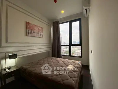 Cozy bedroom with city view, featuring modern decor and large window for natural light.