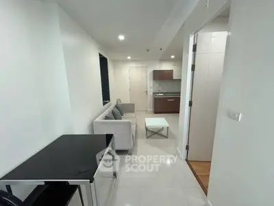 Sleek modern studio apartment with gleaming white tiles, featuring a cozy living area, compact kitchen with wooden cabinets, and a well-lit ambiance perfect for urban living.