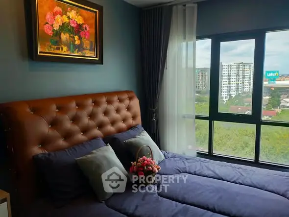 Cozy bedroom with tufted headboard and large window offering city view