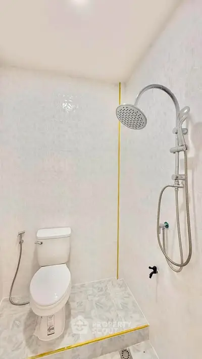 Modern bathroom with sleek shower and toilet in minimalist design.
