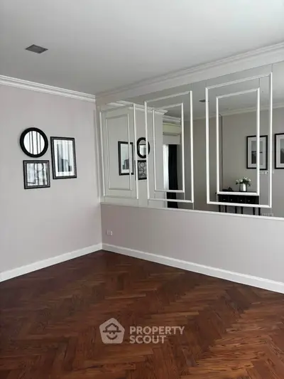 Elegant interior with parquet flooring and mirrored wall, perfect for modern living.