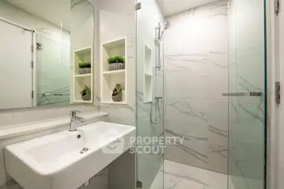 Modern bathroom with sleek design, glass shower, and elegant fixtures.