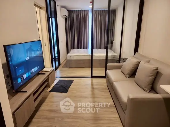 Modern studio apartment with sleek glass partition and cozy living area.