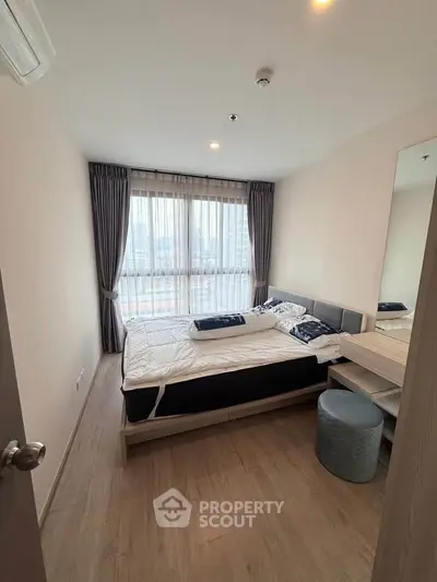 Modern bedroom with large window and stylish decor in a high-rise apartment.