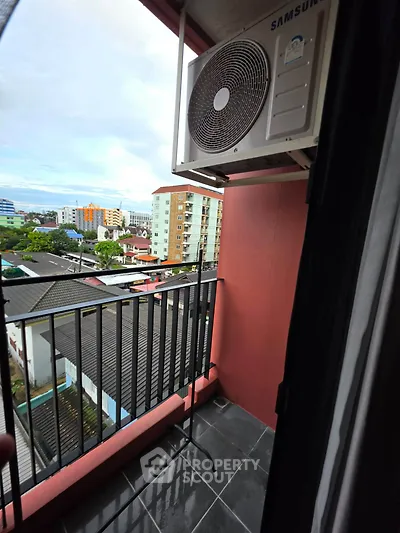 Charming balcony with city view and air conditioning unit, perfect for relaxing outdoors.
