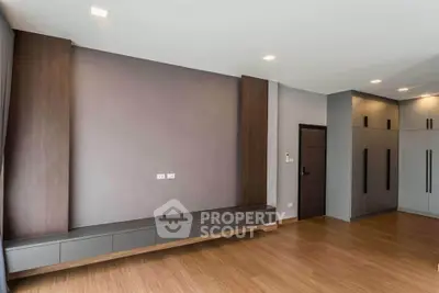 Spacious modern living room with sleek wooden flooring and built-in storage.