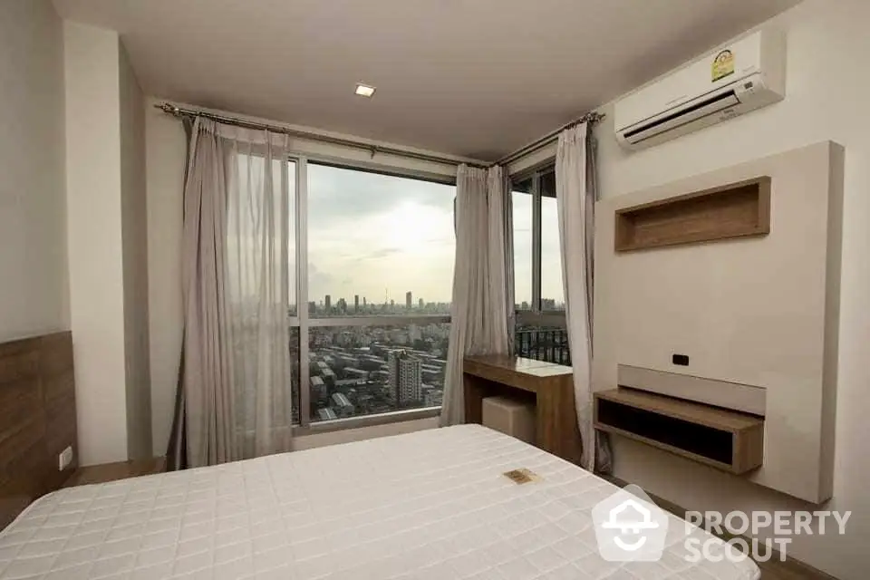 Modern bedroom with panoramic city view and air conditioning in high-rise apartment.