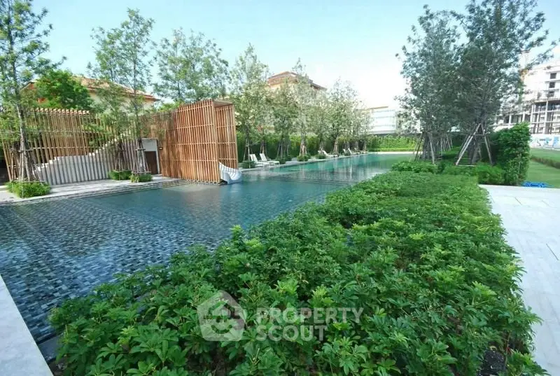 Luxurious outdoor pool surrounded by lush greenery and modern architecture.