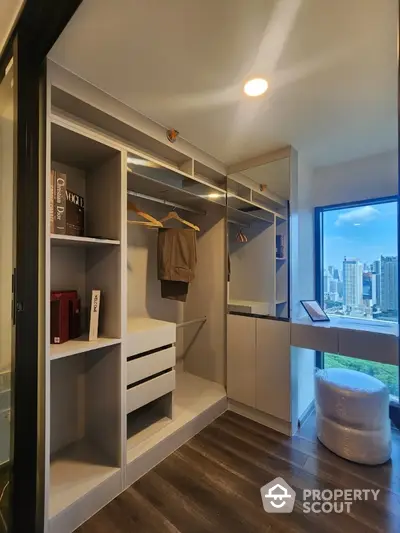 Modern walk-in closet with city view and ample storage space.